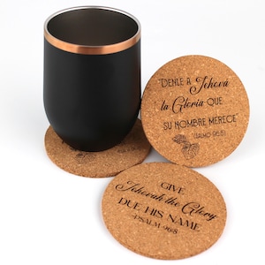 May include: Four cork coasters with a black and copper tumbler on top. The coasters have a leaf design and engraved text in Spanish and English. The text reads "DENLE A Jehová la Gloria QUE SU NOMBRE MERECE (SALMO 96:8)" and "GIVE Jehovah the Glory DUE HIS NAME -PSALM 968".