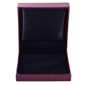 May include: A red faux leather jewelry box with a black velvet interior. The box is open and empty.