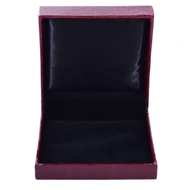 May include: A red faux leather jewelry box with a black velvet interior. The box is open and empty.