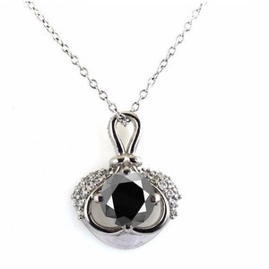 May include: A silver necklace with a black diamond pendant surrounded by smaller diamonds. The pendant is set in a delicate, ornate design.