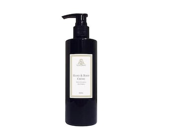 May include: A black bottle of hand and body creme with a pump dispenser. The bottle has a gold label with the text "Hand & Body Creme" and "With Patchouli and Pomelo".