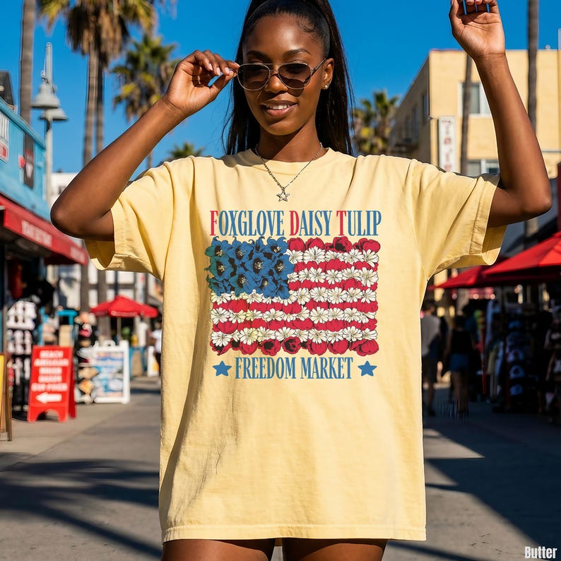 Yellow t-shirt with "Foxglove Daisy Tulip Freedom Market" flag design.