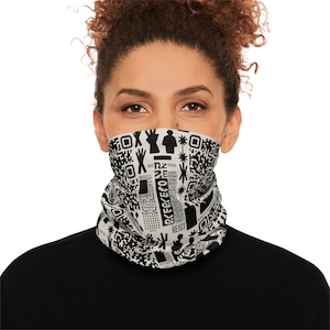 May include: A black and white neck gaiter with a repeating pattern of QR codes, geometric shapes, and text. The text includes the words "RESIST" and "CKECKECO". The gaiter is worn around the neck.