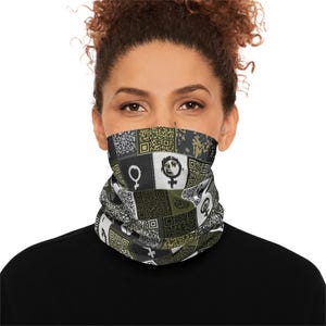 May include: A black neck gaiter with a patchwork design featuring QR codes, the female symbol, and other geometric shapes in shades of black, white, and olive green. The gaiter is worn around the neck and covers the lower face.