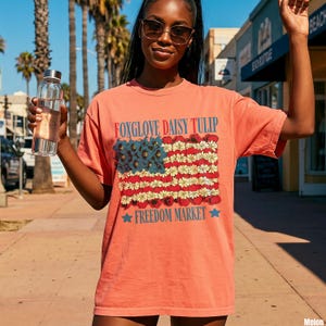 Coral t-shirt with red, white, and blue floral American flag design.