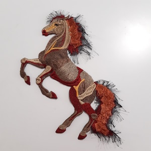 May include: Embroidered iron-on patch of a brown and red horse rearing up on its hind legs. The horse has a black mane and tail.