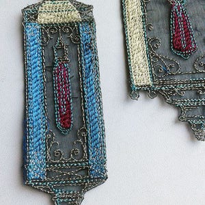 K&ouml;nnte beinhalten: Zwei verzierte, bestickte Stoffst&uuml;cke. Das Hauptst&uuml;ck hat eine rechteckige Form mit blauem Rand und einem zentralen Design in Rot und Blau. Das zweite St&uuml;ck ist &auml;hnlich, mit einem cremefarbenen Rand und einem rot-blauen Design.