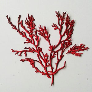 May include: A red, intricate, paper-cut design of a branch with many small twigs and leaves.