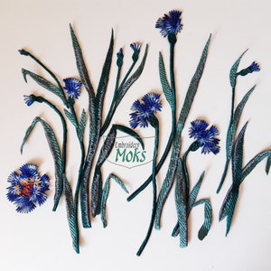 Pode incluir: Um conjunto de aplicações de flores bordadas em azul e verde. As flores são açafrão, também conhecidas como botões de solteiro. As aplicações são perfeitas para adicionar um toque de natureza às suas manualidades.