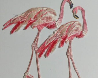 Könnte beinhalten: Zwei gestickte rosa Flamingo-Aufnäher mit weißen Akzenten. Die Flamingos schauen sich mit gebogenem Hals an.
