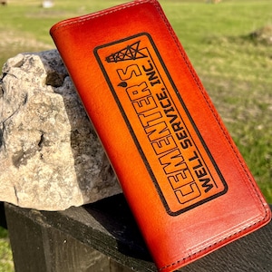 May include: A red leather wallet with a brown engraved logo that reads "Clemente's Well Service, Inc."