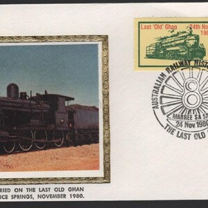 May include: Envelope with a framed image of a black steam train, a stamp with a train, and a stamp with a bird. The envelope is stamped with "Australian Railway Historical Society" and "The Last Old Ghan". Text reads: "This article was carried on the Last Old Ghan Train - Marree to Alice Springs, November 1980."