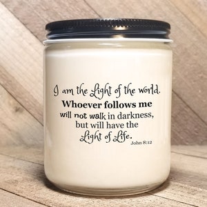 May include: White candle jar with a black lid. The jar has a quote printed on it: "I am the Light of the world. Whoever follows me will not walk in darkness, but will have the Light of Life. John 8:12"