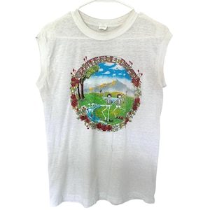 May include: White sleeveless t-shirt with a colorful graphic. The graphic features a landscape with skeletons, a river, and mountains, surrounded by roses. The text "Grateful Dead" is arched across the top of the design.