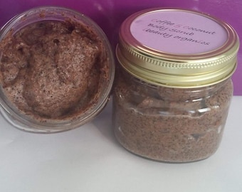 May include: Two glass jars filled with a brown coffee and coconut body scrub. The jar on the right has a gold lid with a label that reads "Coffee & Coconut Body Scrub Beauty Organics".