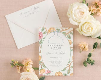 May include: A rehearsal dinner invitation with floral design, an envelope, and white roses on a pink background. The invitation includes the names Jasmine & Alisha, the date August 18, 2023, and the location.