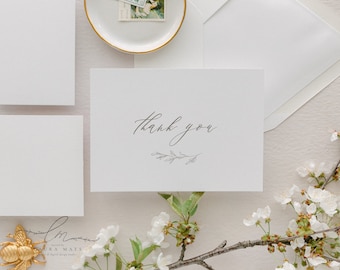 May include: A white thank you card with a simple floral design and the text "thank you" in cursive.