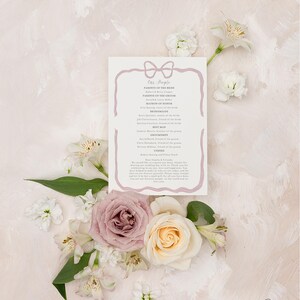 May include: A wedding program with a pink ribbon bow design. The program lists the names of the wedding party members, including the parents of the bride and groom, the matron of honor, and the bridesmaids. The program also includes the names of the groomsmen and the best man.