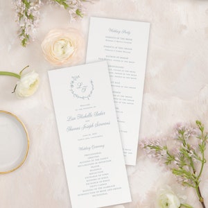 Könnte beinhalten: Ein Programm für eine Hochzeitszeremonie mit einem hellblauen floralen Design und den Namen Lisa Michelle Baker und Thomas Joseph Simmons. Das Programm listet die Hochzeitsgesellschaft, die Reihenfolge der Hochzeitszeremonie sowie das Datum und den Ort der Hochzeit auf.