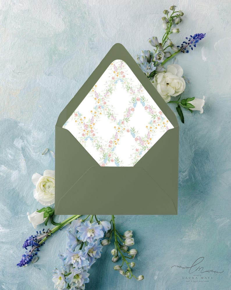 May include: An olive green envelope with a floral patterned interior, featuring a delicate arrangement of pink, blue, and yellow flowers. The envelope is set against a light blue, textured background with white and blue flowers.