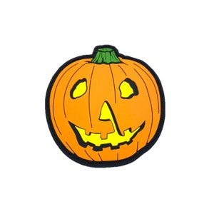 May include: A smiling orange jack-o'-lantern with a green stem and yellow eyes.