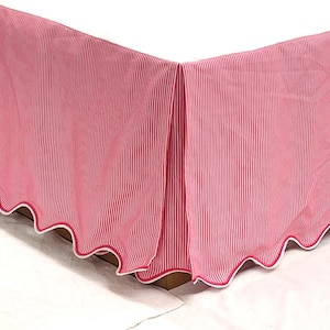 Peut inclure: Une jupe de lit rayée rose et blanche avec un bord festonné. La jupe est faite d'un tissu de coton doux et a un léger brillant.