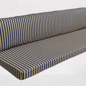 Könnte beinhalten: Ein langes, rechteckiges Bankkissen-Set mit vertikalem Streifenmuster in Marineblau und Beige. Das Set besteht aus einem dicken Sitzkissen und einem passenden Rückenpolster, beide mit geraden Kanten und abgesteppten Nähten.
