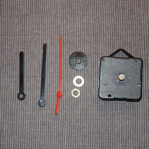 May include: Clock movement kit with black hands, a red second hand, and a black clock mechanism. The kit includes two washers and a nut.