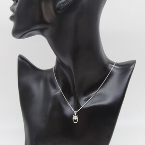 May include: A silver necklace with a small owl pendant. The owl is detailed with small, clear stones.