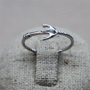 Könnte beinhalten: Ein silberner Ring mit einem gedrehten Band und einem Anker-Design.
