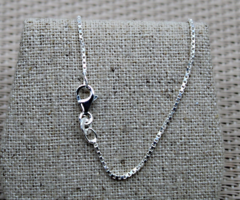 May include: A silver chain necklace with a lobster clasp closure.