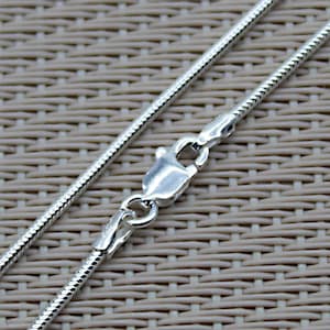 Peut inclure: Un collier en chaîne serpent argenté avec un fermoir à ressort.