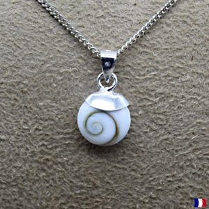 Op de afbeelding: Een zilveren ketting met een hanger van een witte schelp met een spiraalvormig patroon. De schelp is gezet in zilver en hangt aan een fijne ketting. De hanger toont een natuurlijk, wervelend patroon in bruine en crèmetinten.