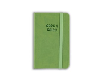 May include: A rectangular notebook with a solid light green cover and a matching vertical elastic closure band. The front cover features the dark green text "oops a daisy" printed in a rounded, playful font style near the top center.