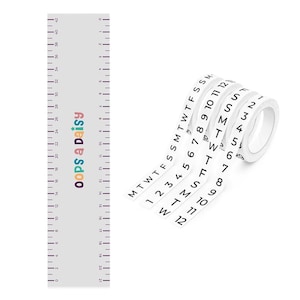 Könnte beinhalten: Ein weißes Lineal mit schwarzen Markierungen und dem Text "oops a daisy" in bunten Buchstaben. Eine Rolle weißes Klebeband mit schwarzen Zahlen und Wochentagen ist ebenfalls abgebildet. Das Klebeband ist mit den Zahlen 1-12 und den Wochentagen beschriftet.