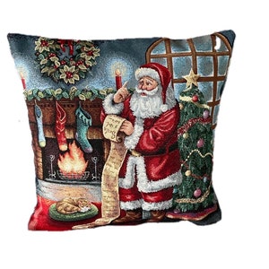 Könnte beinhalten: Ein festliches Weihnachtskissen mit einem Weihnachtsmann, der eine Liste hält, einem beleuchteten Kamin mit hängenden Strümpfen und einem geschmückten Weihnachtsbaum. Das Kissen hat einen blauen Hintergrund mit einem roten Rand.