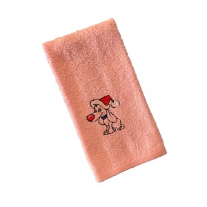 Könnte beinhalten: Ein rosa Handtuch mit einem gestickten Bild eines Hundes, der einen Weihnachtsmann-Hut trägt.