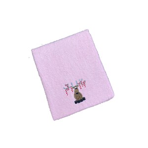 Könnte beinhalten: Rosa Handtuch mit einem gestickten Rentier mit Zuckerstangen an seinen Geweih.