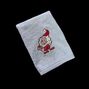 Könnte beinhalten: Weißes Handtuch mit einem gestickten Bild eines rosa Comic-Charakters, der eine rote Weihnachtsmütze trägt und ein Geschenk hält.