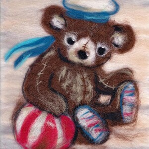 May include: A brown teddy bear wearing a blue and white sailor hat and blue shoes sits with a red and white striped ball. The bear is made of felt and has a stitched nose and mouth.