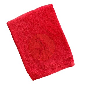 Könnte beinhalten: Ein rotes Handtuch mit einem roten gestickten Kreis, der ein Sternmuster enthält.