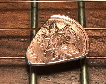 Könnte beinhalten: Eine kanadische Ein-Cent-Münze wurde zu einem Gitarrenplektrum umfunktioniert. Die Münze zeigt ein Ahornblatt-Design und das Jahr 2004.