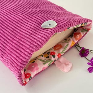 Pochette livre tissu molletonnée fermeture par un bouton, housse protection livre format poche. Velours côtelé rose et fleurs d’été
