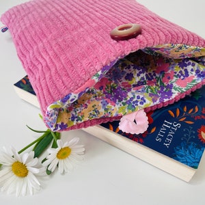 Astuccio imbottito in tessuto con chiusura a bottone, copertina tascabile. Velluto a coste rosa.