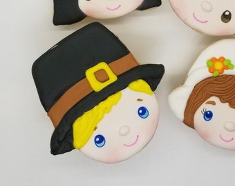 May include: Four decorated sugar cookies, each depicting a different character. The cookies are decorated with colorful icing and feature details like feathers, hats, and flowers.
