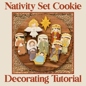 May include: A set of nine decorated Christmas cookies depicting the Nativity scene. The cookies are arranged on a wooden platter with a woven straw background. The cookies include Mary, Joseph, baby Jesus, an angel, a star, and three wise men.