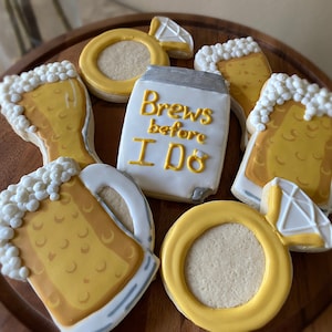 May include: A set of six decorated sugar cookies featuring a beer mug, a beer glass, a ring, and a cookie with the text "Brews before I do".