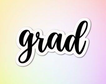 May include: Black cookie cutter in the shape of the word "grad" in a cursive font. The cookie cutter is on a white background.