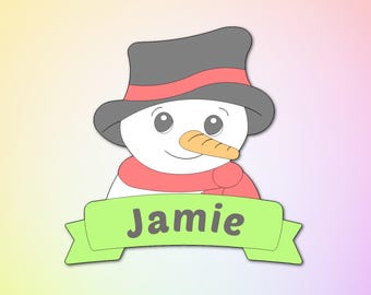May include: A green banner with the name "Jamie" on it, with a cartoon snowman wearing a red scarf and a black top hat. The snowman has a carrot nose and black eyes. The background is a gradient of pink, yellow, and orange.