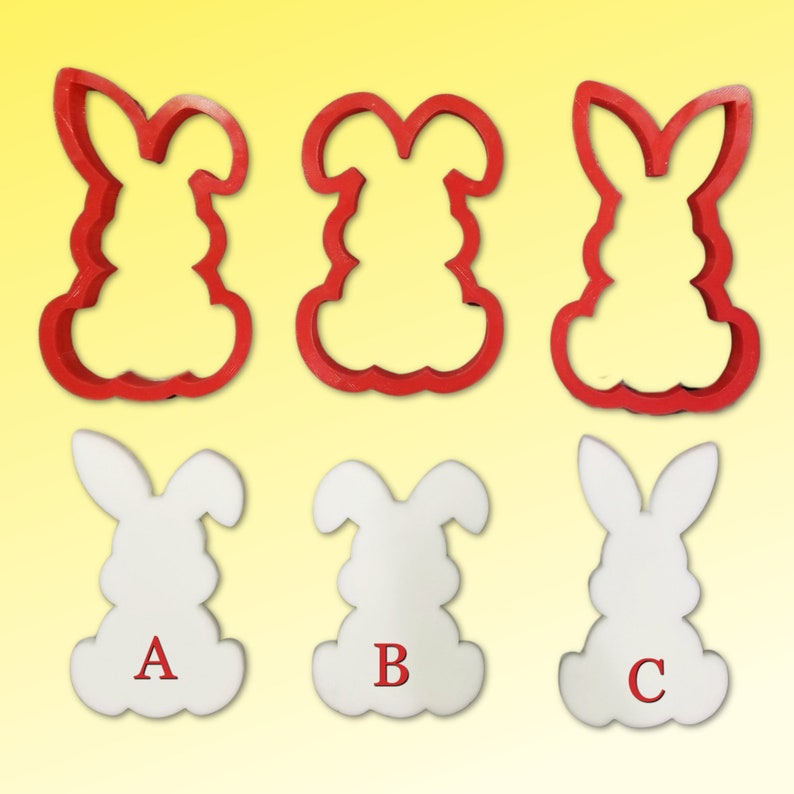 May include: Three red plastic bunny cookie cutters and three white plastic bunny cookies with the letters A, B, and C on them.